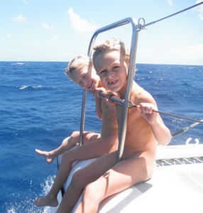 2 enfants à l avant du catamaran dans le Pacifique